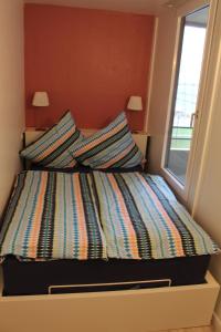 a bed with two pillows on it next to a window at Ferienappartements Marina Wendtorf an der Ostsee in Wendtorf