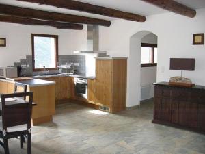 a large kitchen with wooden cabinets and a tv at Les GITES DE CAMPARAN - gîte "la BERGERIE AVEC SPA" in Camparan