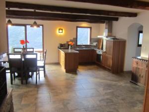 uma grande cozinha e sala de jantar com mesa e cadeiras em Les GITES DE CAMPARAN - gîte "la BERGERIE AVEC SPA" em Camparan