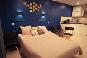 カンヌにあるDelaup Sea Cannesの青い壁のベッドルーム1室(大型ベッド1台付)