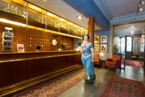 a woman in a blue dress standing in a lobby at Lady Hamilton Hotel in Stockholm