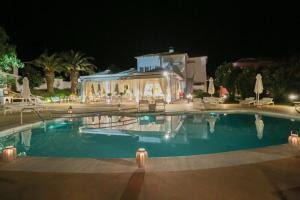 a swimming pool in a resort at night at Mandraki Village Boutique Hotel in Koukounaries