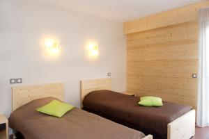 zwei Betten in einem Zimmer mit Holzwänden in der Unterkunft Les Hauts du Gevaudan in Montrodat