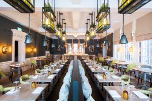 a restaurant with tables and chairs and chandeliers at The Swan Hotel in Southwold