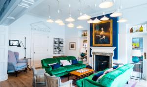 a living room with a green couch and a fireplace at The Swan Hotel in Southwold