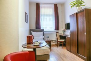 a room with a table and a chair and a desk at City Residence Hotel Frankfurt-Oder Bahnhof in Frankfurt/Oder