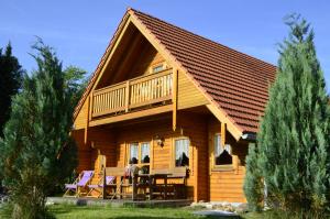 Cabaña de madera con terraza, mesas y sillas en Bayerwaldblockhaus, en Philippsreut