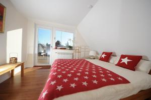 een slaapkamer met een bed met rode en witte kussens bij Exklusiv Wohnung Nika in Westerland