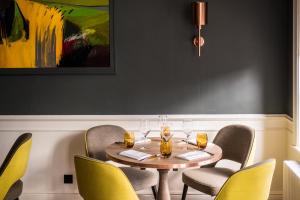 a dining room with a table with chairs and a painting at The Swan Hotel in Southwold