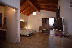a bedroom with a bed and a flat screen tv at Agriturismo al Riparo dai Venti in Stintino