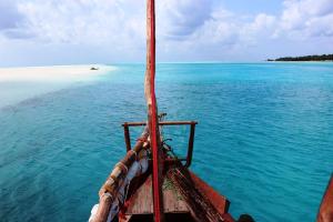 a boat in the water with a view of the ocean at Emerald Bay Resort in Kizungu