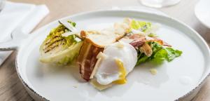 a white plate with a salad and an egg on it at The Swan Hotel in Southwold