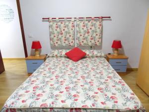 a bed in a room with two lamps on tables at Apartamentos Capuchinas in Plasencia