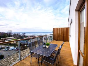 a balcony with a table and chairs and the ocean at VacationClub - Olympic Park Apartment A604 in Kołobrzeg