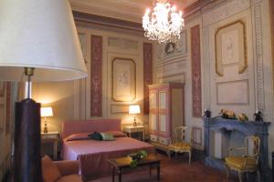 sypialnia z łóżkiem i żyrandolem w obiekcie Residenza d'Epoca Palazzo Galletti we Florencji