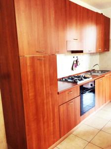 a kitchen with wooden cabinets and a stove top oven at Le case di Pone in Cologno Monzese