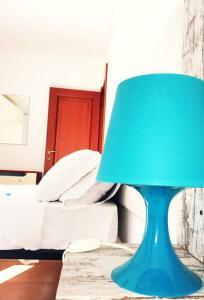 une lampe bleue assise sur une table à côté d'un lit dans l'établissement Le case di Pone, à Cologno Monzese