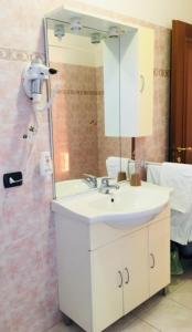 La salle de bains est pourvue d'un lavabo blanc et d'un miroir. dans l'établissement Le case di Pone, à Cologno Monzese