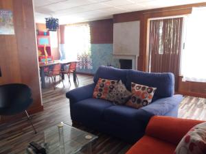 a living room with a blue couch and a table at Huerta La Cansina in Mairena del Alcor