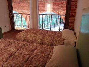 a bedroom with a bed and a large window at Agriturismo La Sophora in Montegaldella