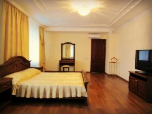 a bedroom with a large bed and a television at Gostiniy Dvorik Guest House in Yaroslavl