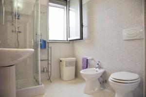 a bathroom with a toilet and a sink and a shower at Casa Solento in Campomarino +37 photos