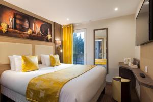 ein Hotelzimmer mit einem großen Bett und einem Fernseher in der Unterkunft Comfort Hotel Orléans Olivet Provinces in Olivet