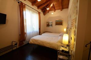 a bedroom with a large bed and a window at Locanda Gli Ulivi in Monteveglio
