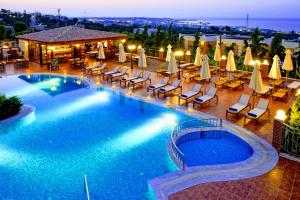 a large swimming pool with chairs and umbrellas at Ippoliti Village in Hersonissos