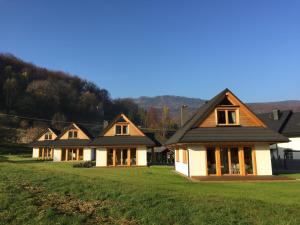 una fila de casas en un campo de hierba en Chaty pod Beskidkiem en Szczyrk