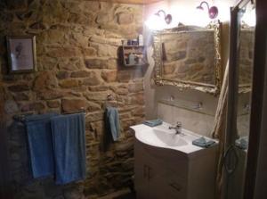 a stone bathroom with a sink and a mirror at Colonial Cottages of Ross in Ross