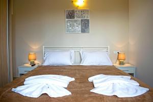 ein Schlafzimmer mit einem Bett mit zwei weißen Handtüchern darauf in der Unterkunft Villa Campos- Less than 5-Min Walk to Kalivaki Beach in Georgioupoli