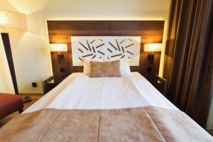 a bedroom with a large white bed with a wooden headboard at Hotell Östersund in Östersund