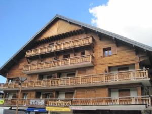 ein Holzgebäude mit Balkon auf der Seite in der Unterkunft Les Azalées 7 in Les Gets