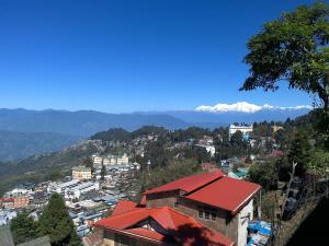 uitzicht op een stad met bergen op de achtergrond bij Hideout Homestay in Darjeeling