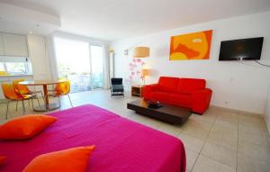 a living room with a red bed and a red couch at Modern Golden Apartment in Cabanas de Tavira