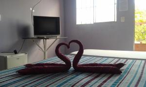 dos cisnes rojos sentados en la parte superior de una cama en Pousada Ana Raio, en Alcobaça