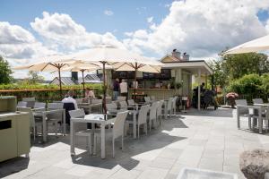 a patio with tables and chairs and umbrellas at Sigtuna Stadshotell in Sigtuna