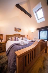 a bedroom with a wooden bed with towels on it at The Lodge in Staffin