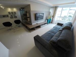 uma sala de estar com um sofá e uma televisão em A075 - Ed. Mônica, cobertura duplex em Bombinhas