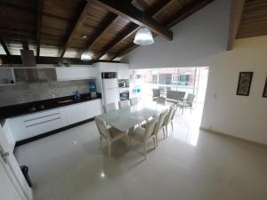 uma cozinha e sala de jantar com mesa e cadeiras em A075 - Ed. Mônica, cobertura duplex em Bombinhas