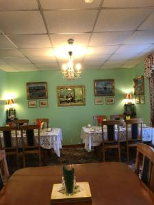 a dining room with tables and chairs and a chandelier at The Stables B&B in Antrim