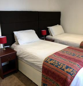 a hotel room with two beds and two lamps at Waverley Hotel in Workington