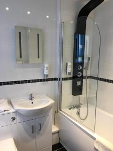 a bathroom with a sink, toilet and shower at Waverley Hotel in Workington