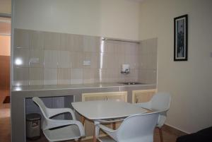een keuken met een tafel en 2 witte stoelen bij Latitude 1 Suites in Kampala