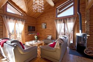 a living room with two chairs and a fireplace at Odalys Chalet Leslie Alpen in Les Deux Alpes
