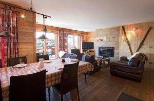 レ・デュー・アルプにあるOdalys Chalet Huskyのリビングルーム(テーブル、椅子、暖炉付)