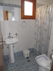 a bathroom with a sink and a toilet at Saint Nicolas Bungalows in Arkasa