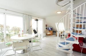 un salon avec une table et des chaises blanches dans l'établissement Fesker-5, à Morsum