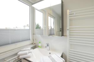 une salle de bain blanche avec un lavabo et un miroir dans l'établissement Fesker-5, à Morsum